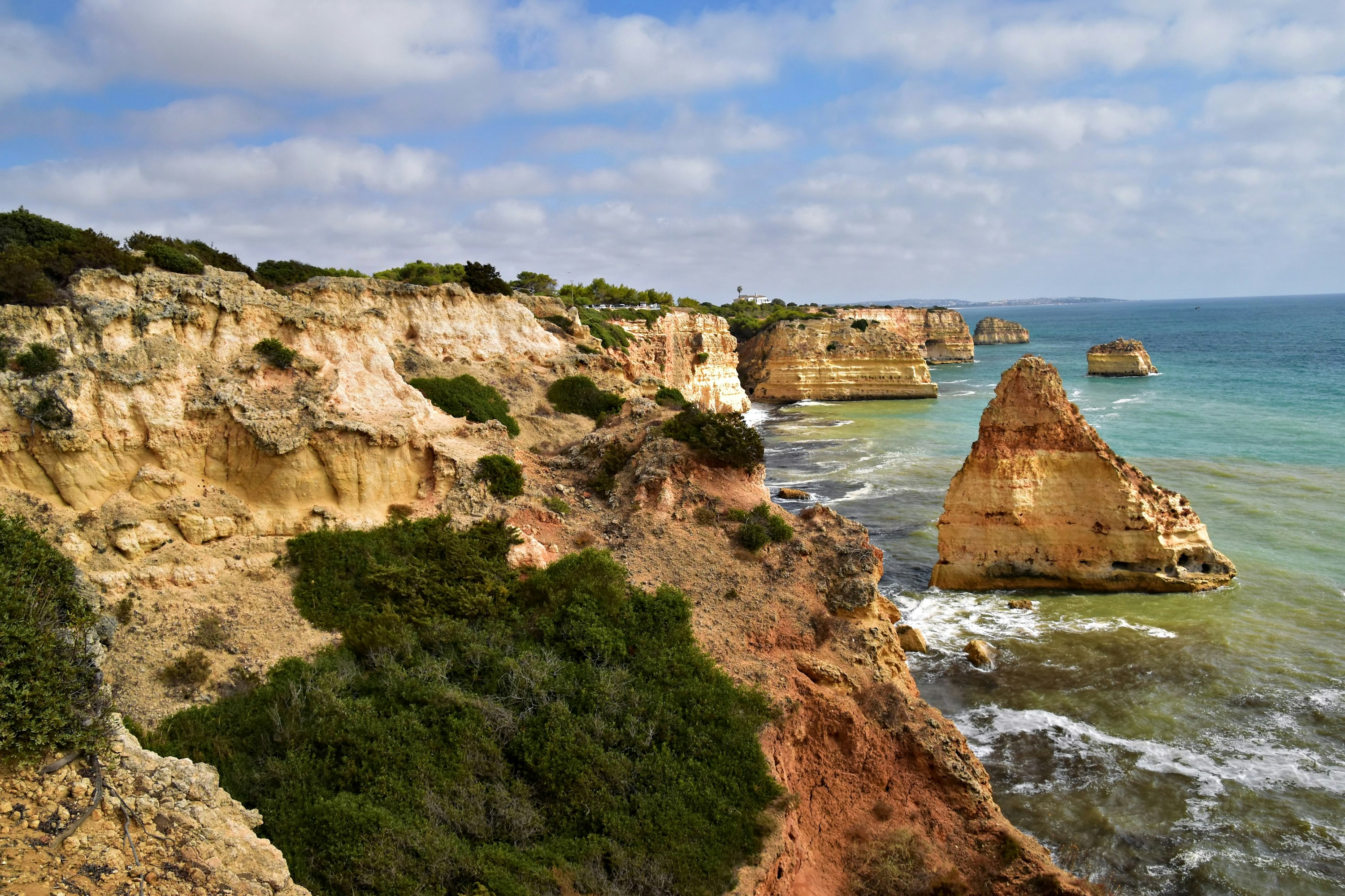 Praia da Marinha — côte rocheuse calcaire dorée avec eau turquoise translucide en pleine lumière, Algarve, Portugal