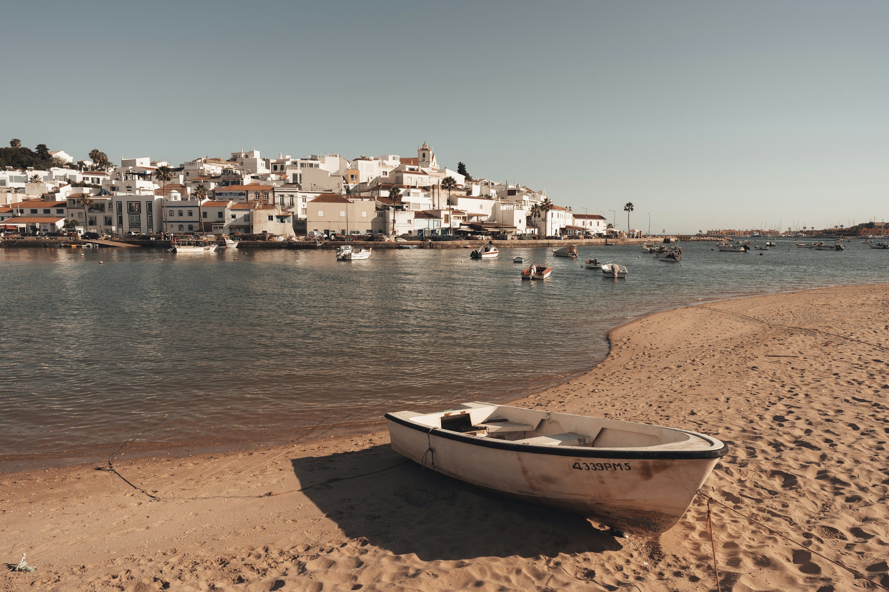 Barque échouée sur la plage face au village côtier de Ferragudo, Algarve, Portugal