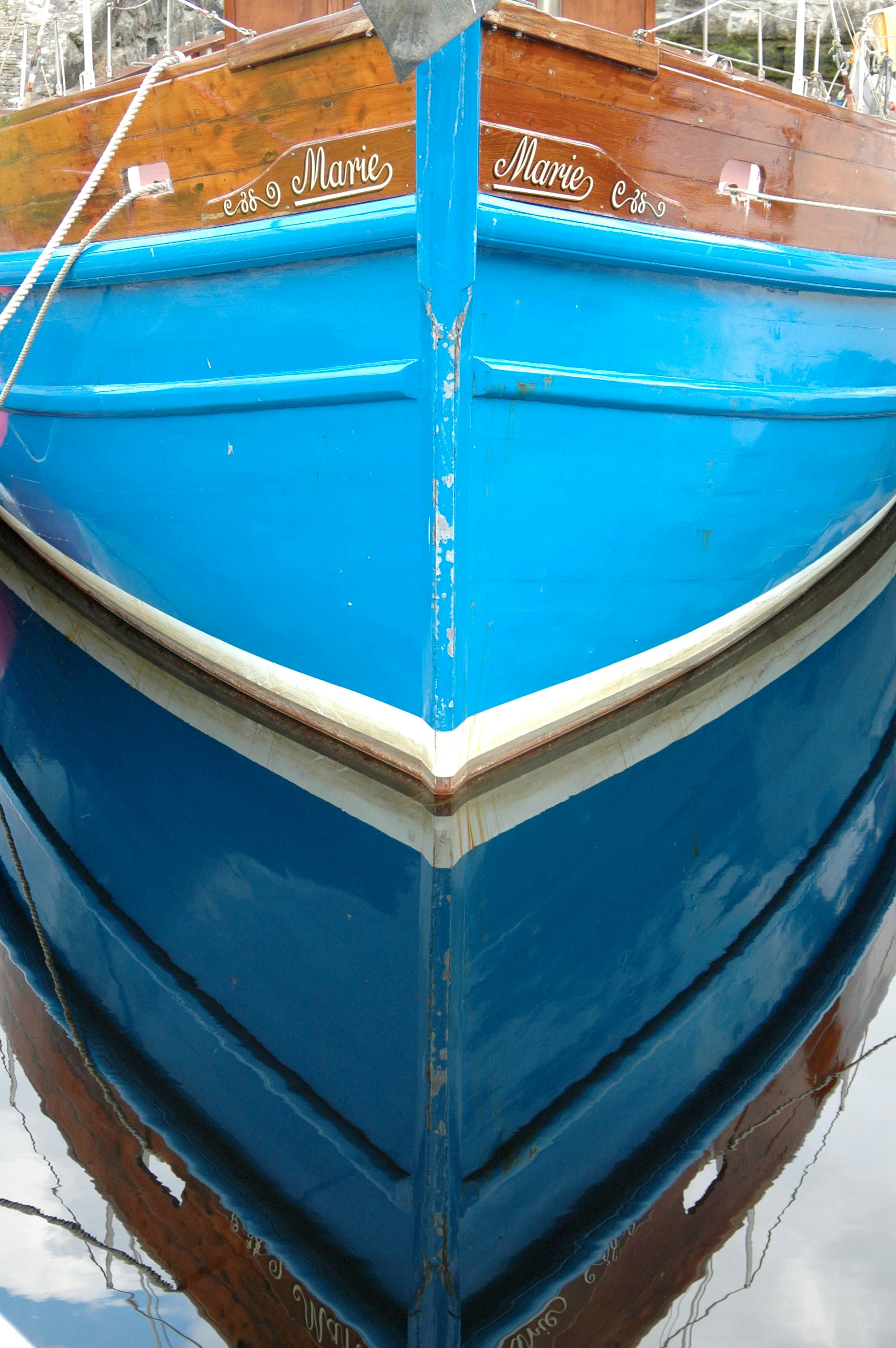 A small blue fishing boat tied up at its moorings on the west coast
