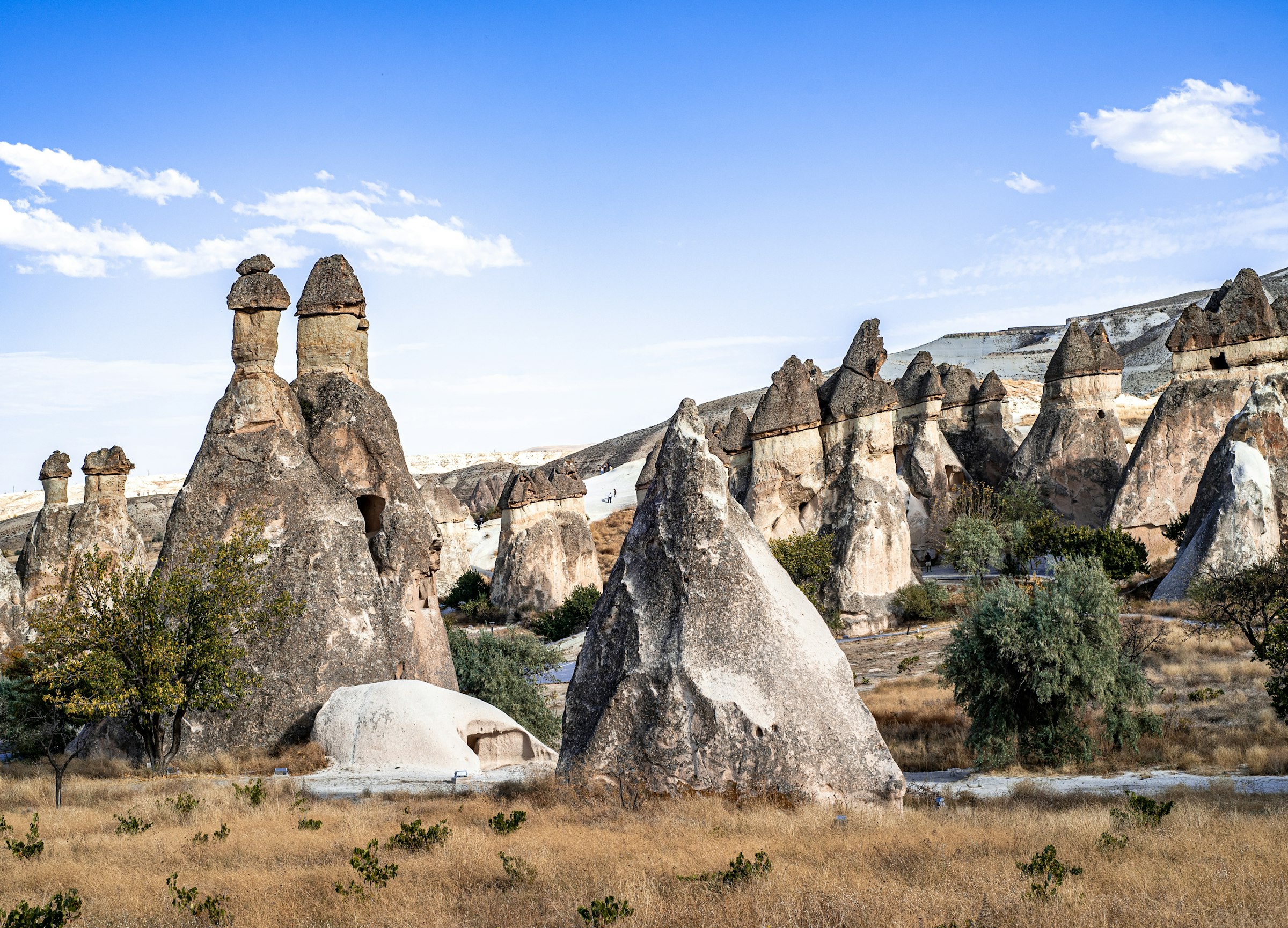 Des cheminées de fée en champignon dans une vallée de Cappadoce, sous un ciel bleu, sans foule ni montgolfière.