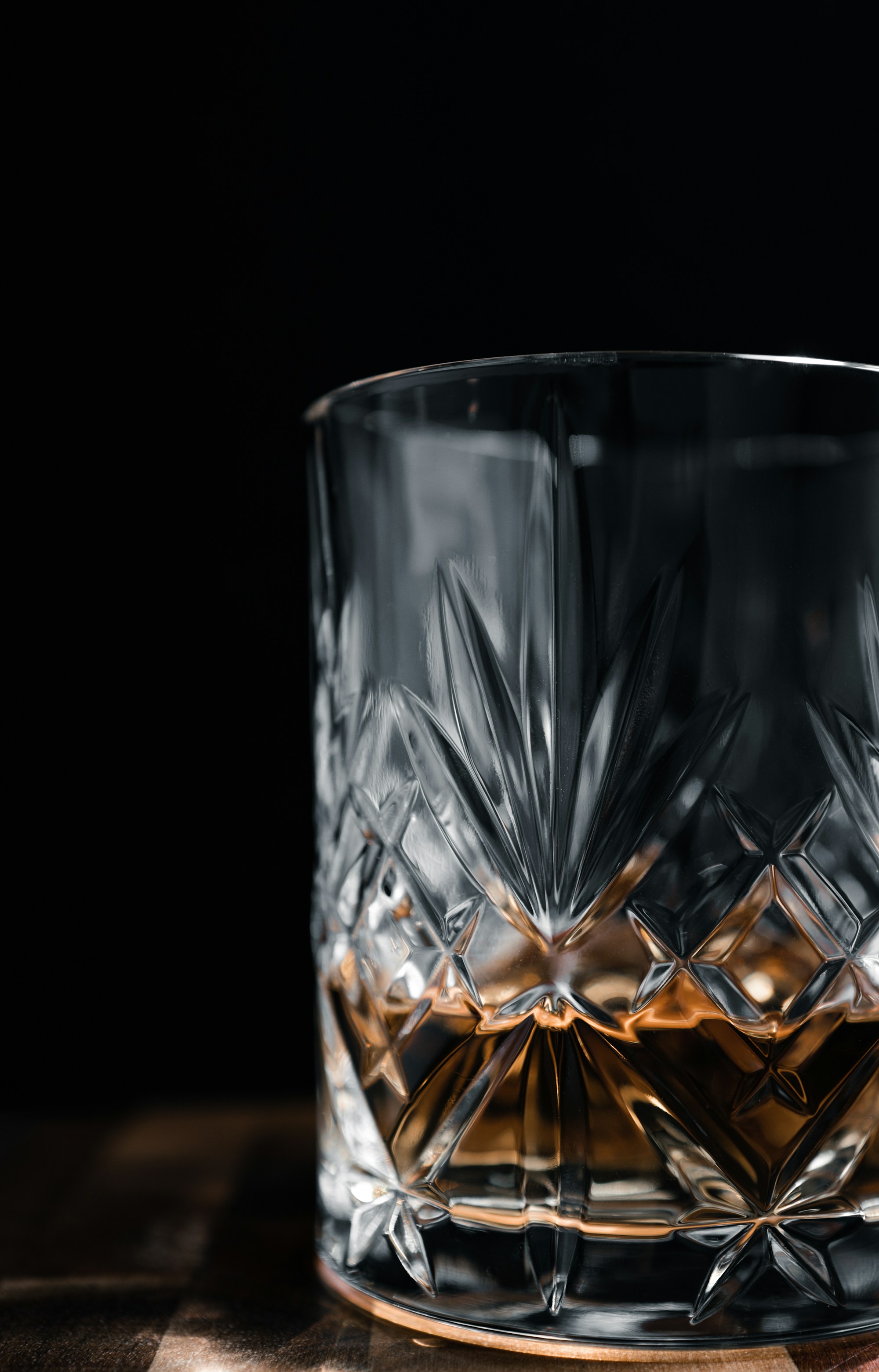 A glass of whisky on a wooden table