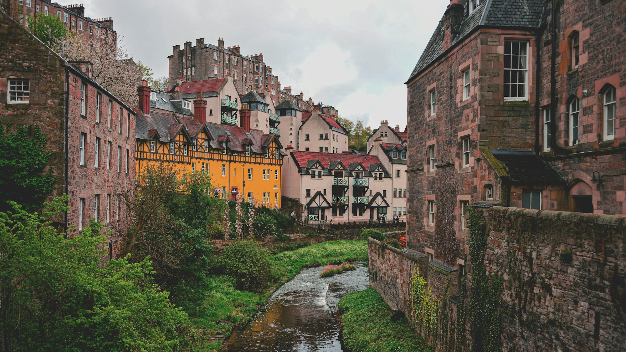 Historic stone buildings lining a small river in a European city