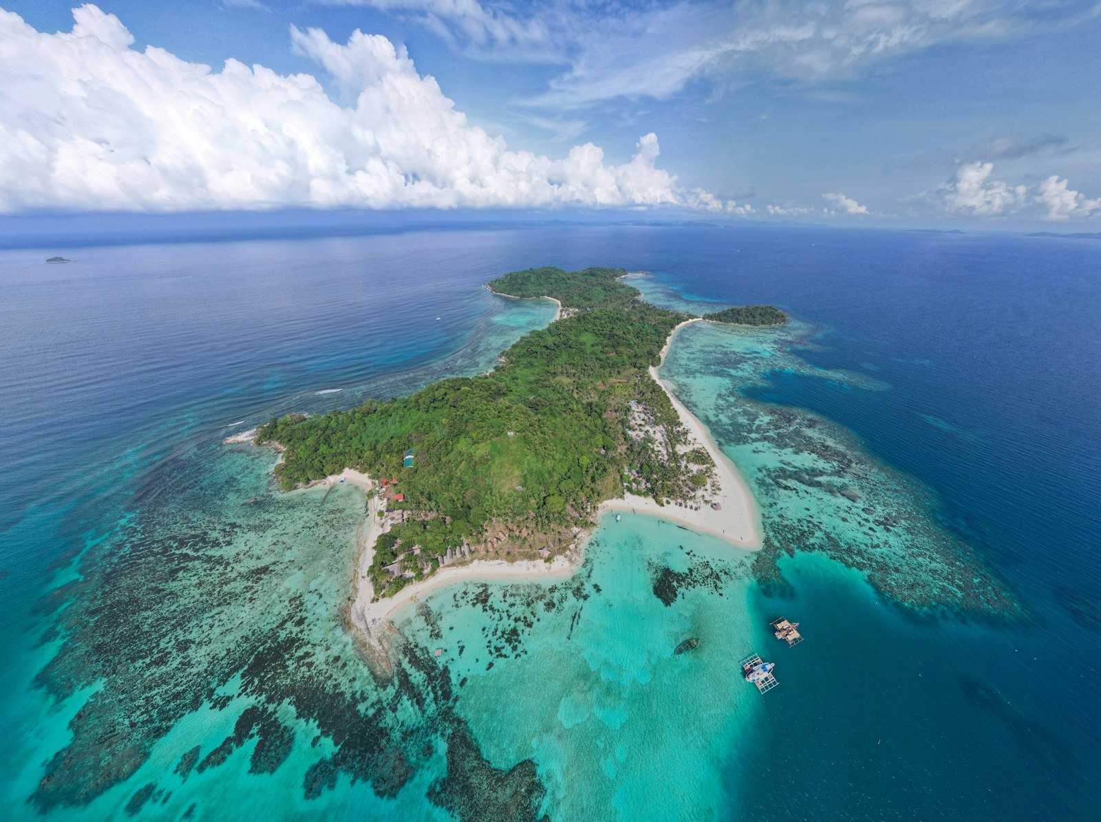 Une petite île tropicale cernée d'eau turquoise et de récifs, vue du ciel — esprit d'Apo Island