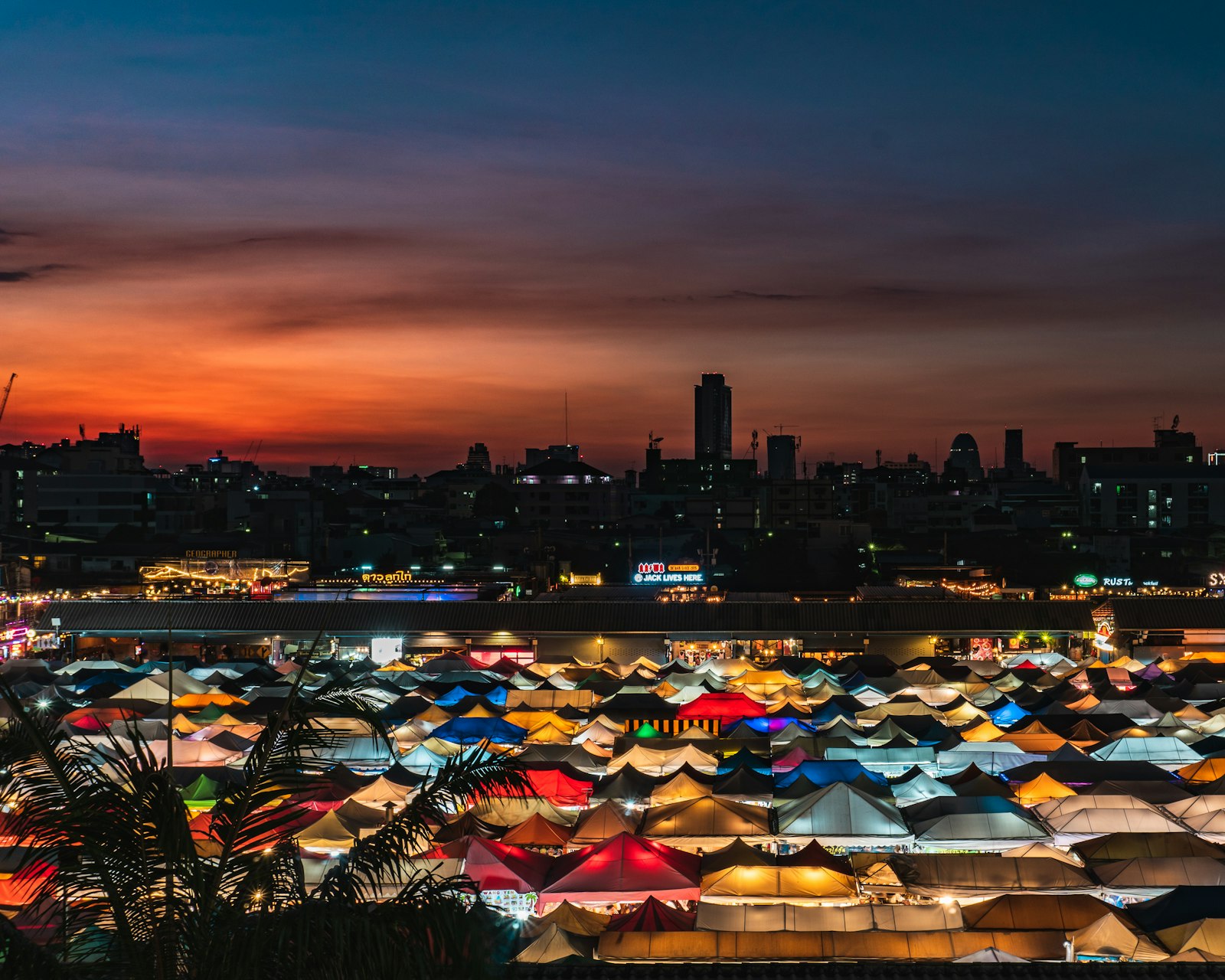 Les tentes colorées d'un marché de nuit illuminées à la tombée du jour, Bangkok