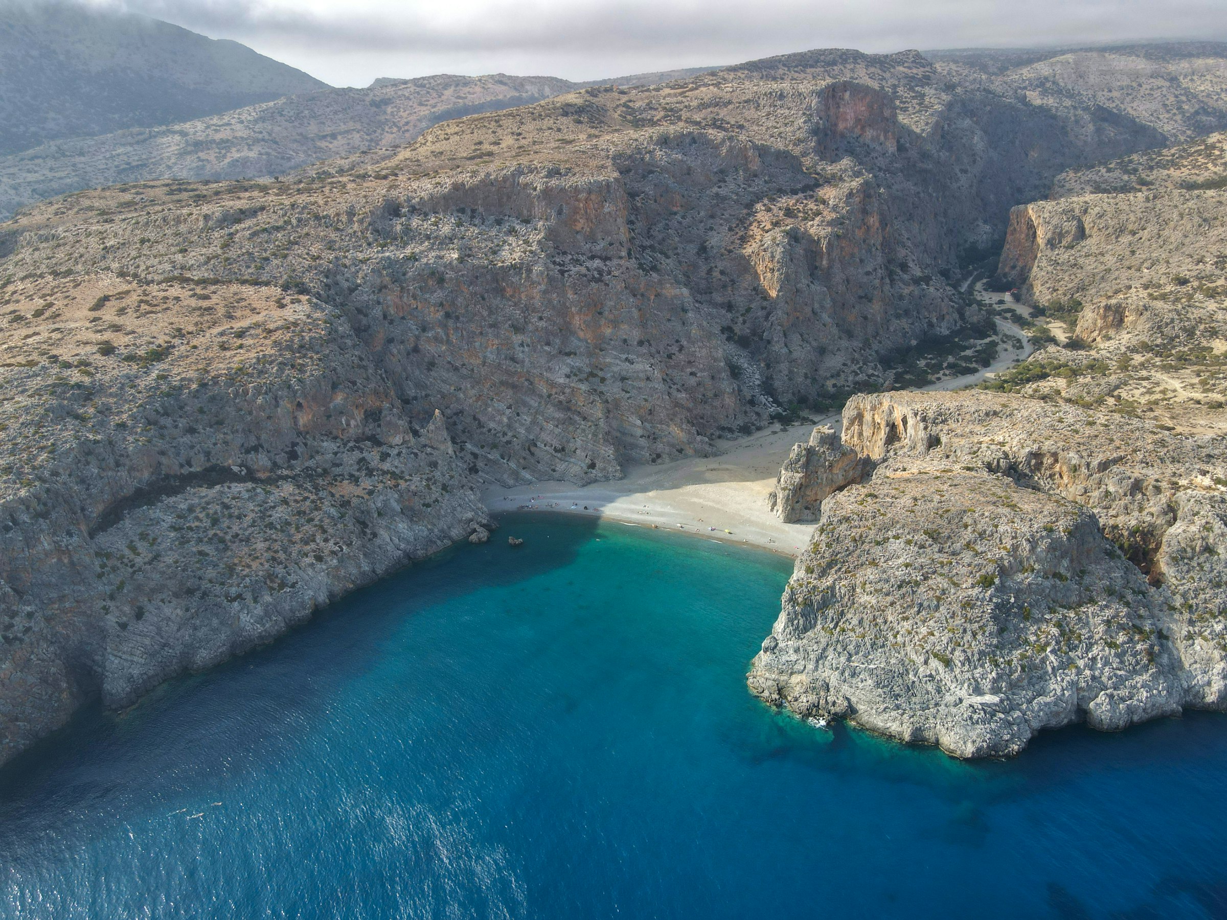 Une crique sauvage et isolée au débouché d'une gorge de la côte sud de la Crète : une petite plage de galets coincée entre de hautes parois rocheuses, une eau turquoise profonde, presque personne.