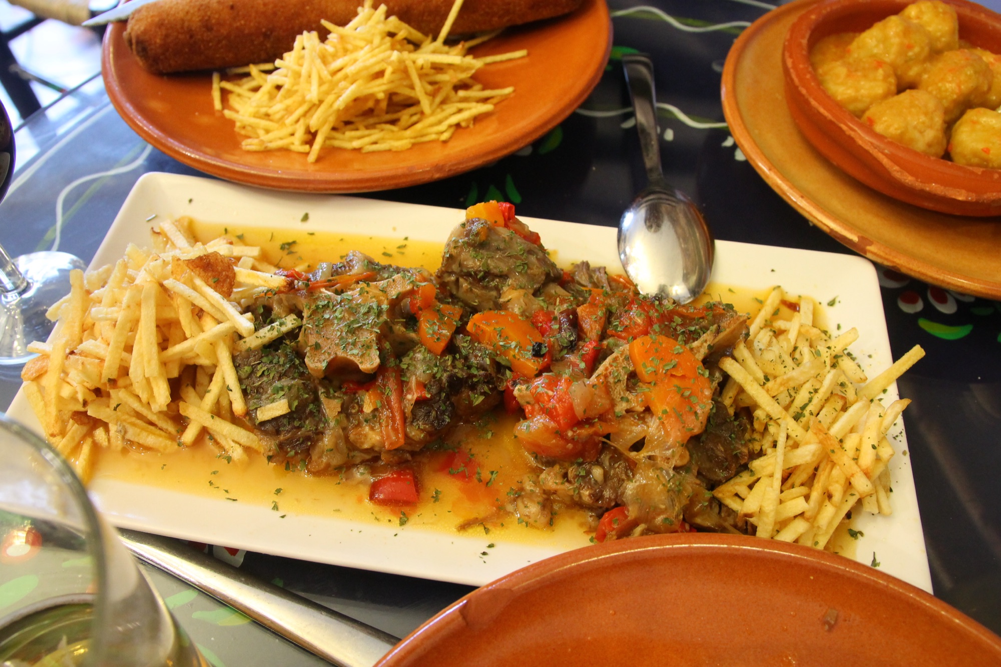 Assiette de rabo de toro — queue de taureau braisée en sauce, servie avec des frites