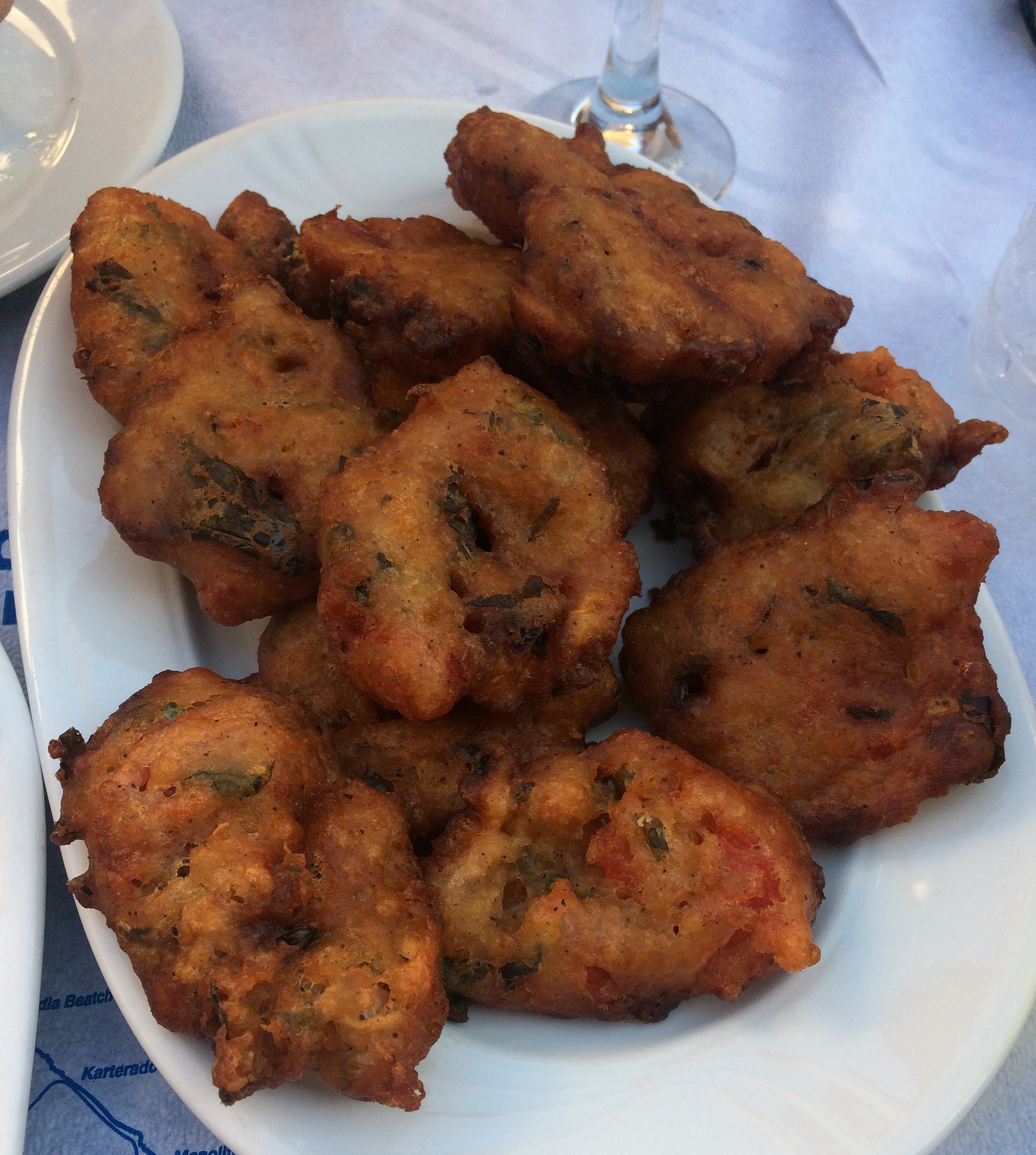Une assiette de beignets de tomate dorés sur une table de taverne, à Santorin