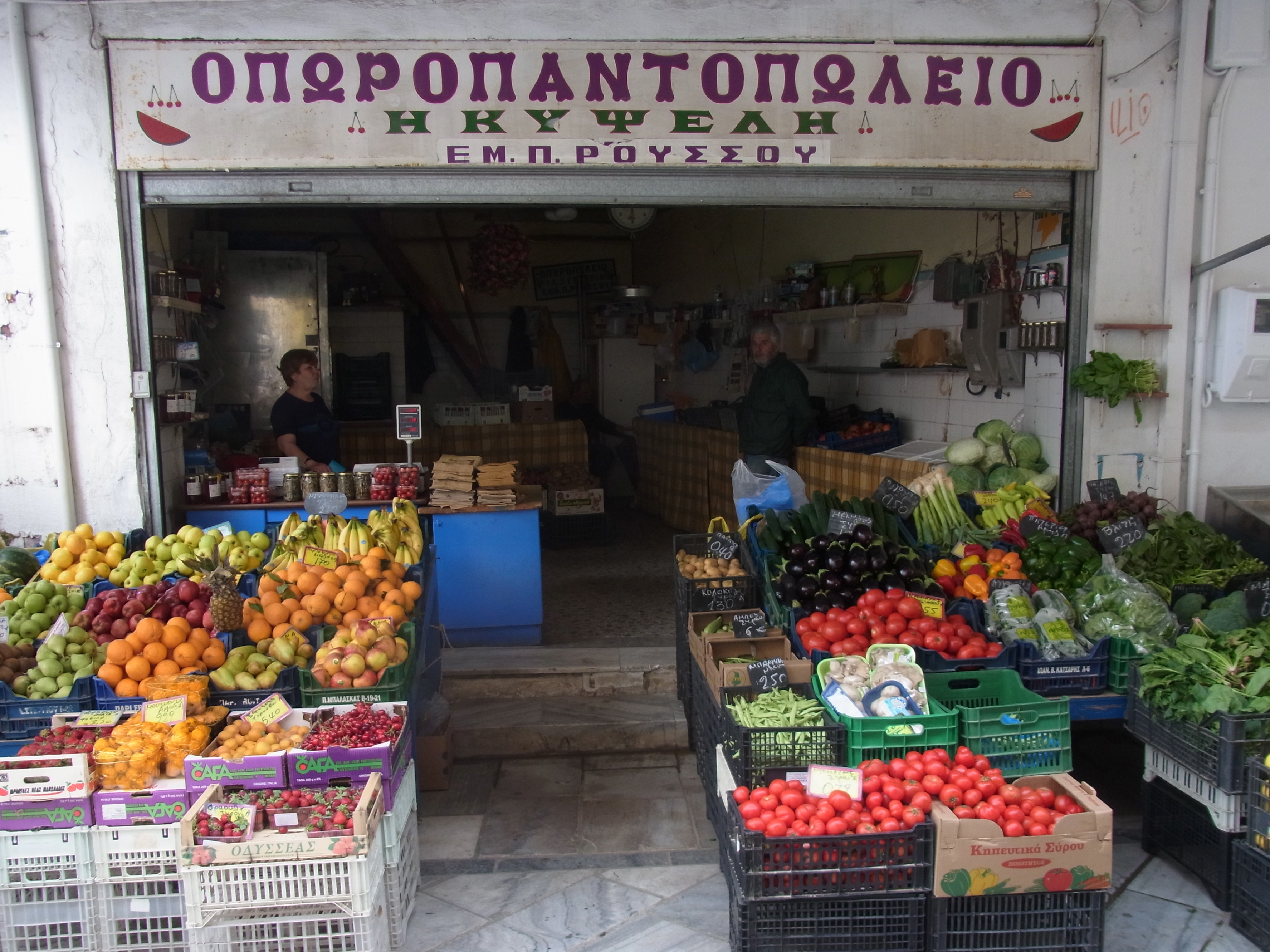 L'étal coloré d'une épicerie de fruits et légumes d'Ermoupoli : cageots de tomates, poivrons, aubergines, oranges et légumes verts
